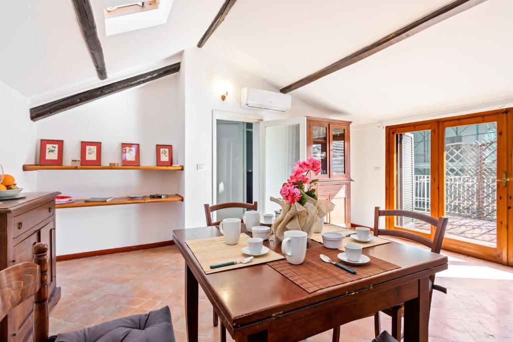 una sala da pranzo con tavolo e fiori di Libertà Frame Apartment with Terrace and Etna view a Catania