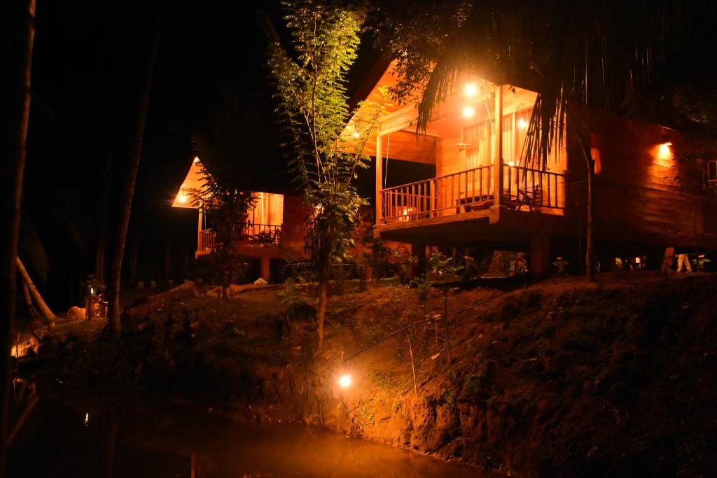 una casa con balcón por la noche con luces en Wild Lake Side en Udawalawe