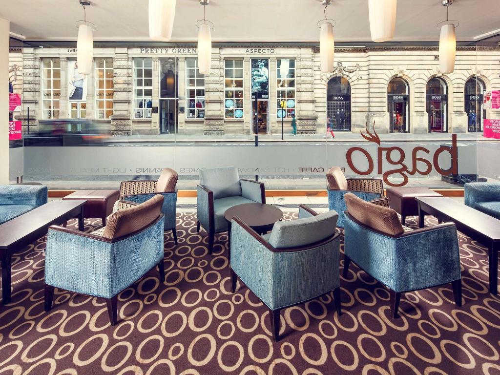 a restaurant with couches and tables in a lobby at Mercure Glasgow City Hotel in Glasgow