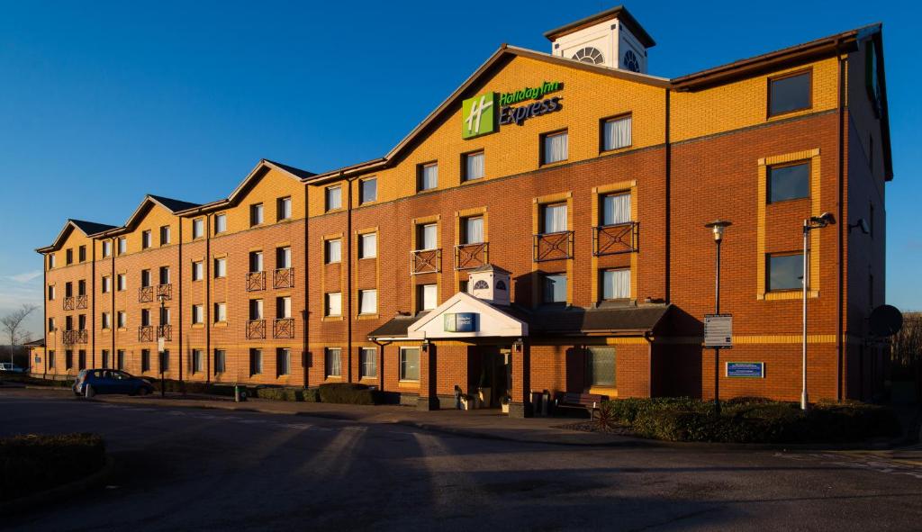 a large brick building with a clock tower on it at Holiday Inn Express Stoke-On-Trent, an IHG Hotel in Stoke on Trent