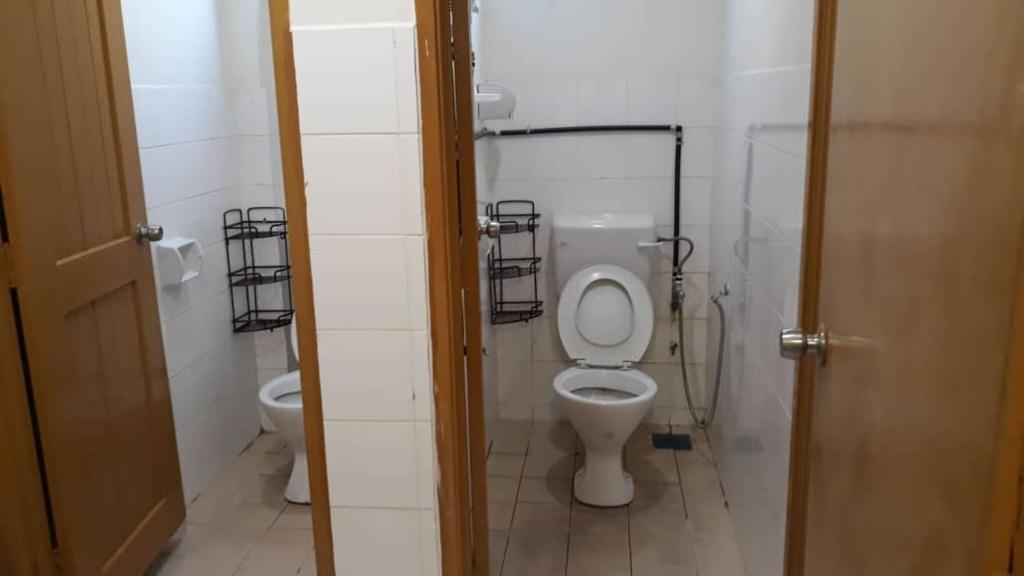 La salle de bains est pourvue de toilettes. dans l'établissement Mjc New township 6BR by Natol Homestay-MJC, à Kuching