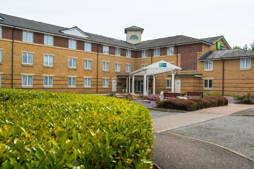 un gran edificio de ladrillo con un seto delante de él en Holiday Inn Express Stirling, an IHG Hotel, en Stirling