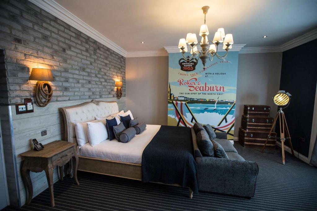 een slaapkamer met een groot bed en een bank bij Roker Hotel BW Premier Collection in Sunderland