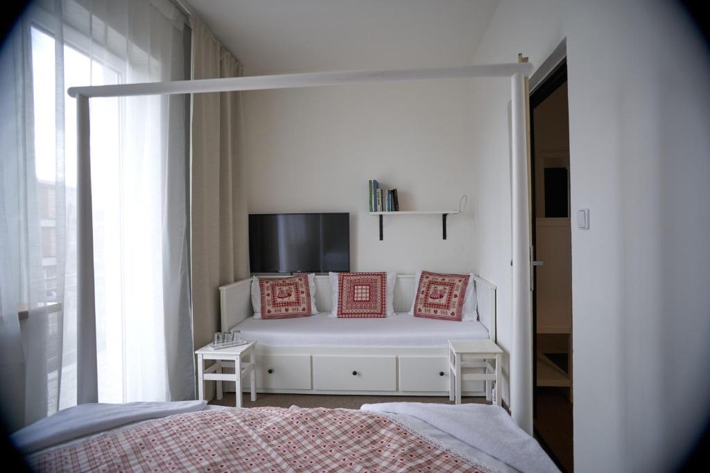 Un dormitorio con una cama con almohadas rojas. en Penzión SENEC, en Senec