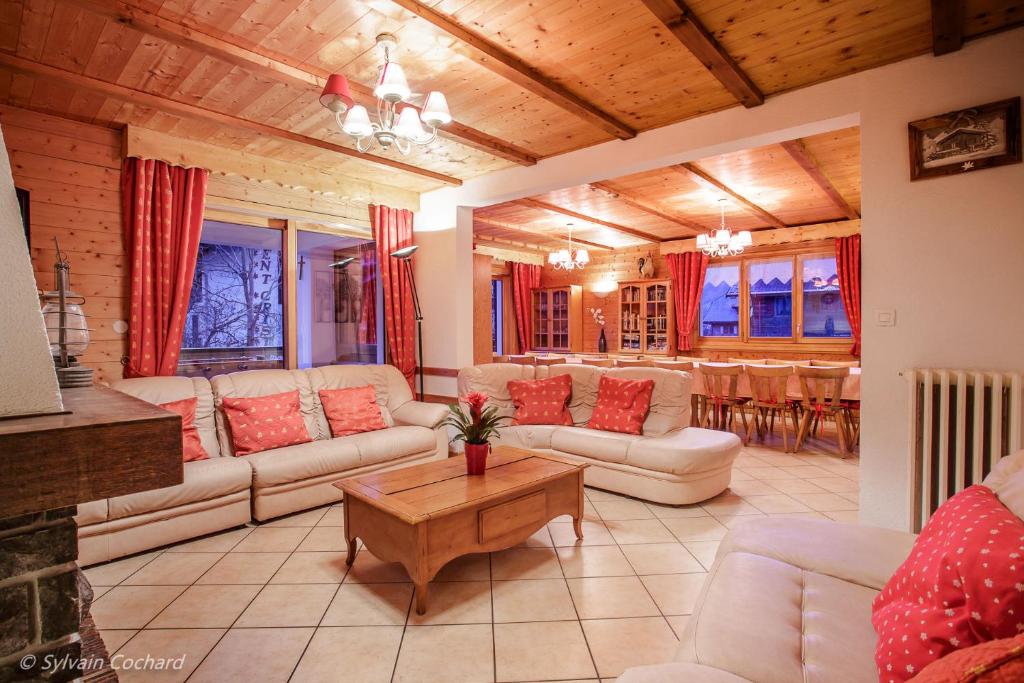 a living room with white couches and a table at Chalet Bellevue in La Chapelle-dʼAbondance