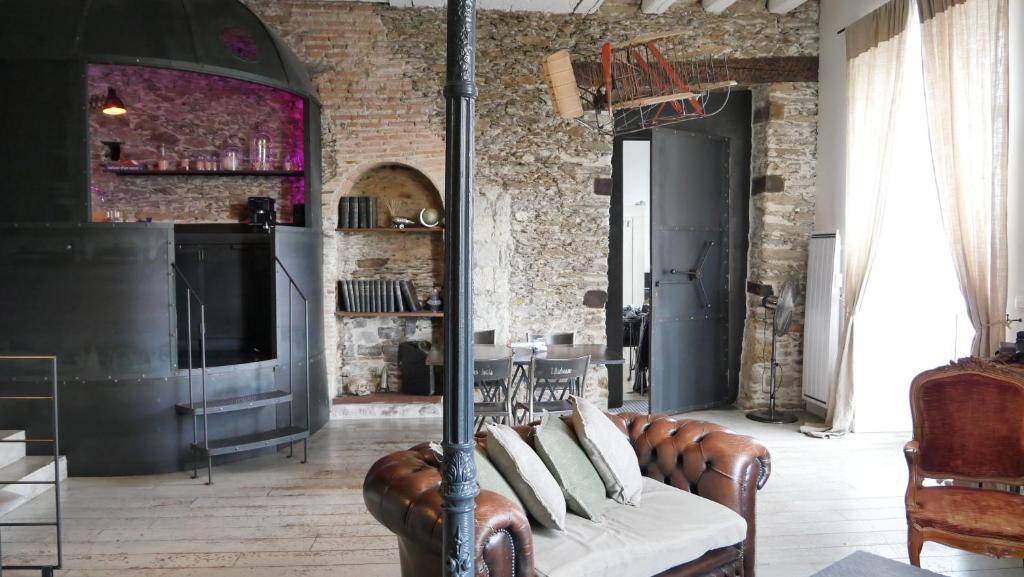 ein Wohnzimmer mit einem Sofa und einem TV in der Unterkunft Surprenantes- Jules Verne in Nantes