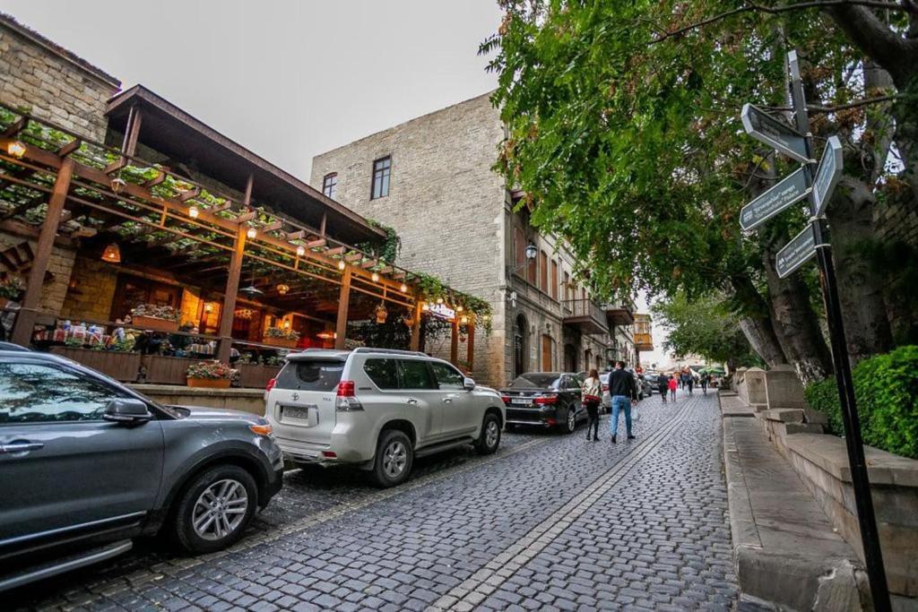 una calle con coches estacionados al costado de la carretera en Cozy Old City Apartment, en Baku