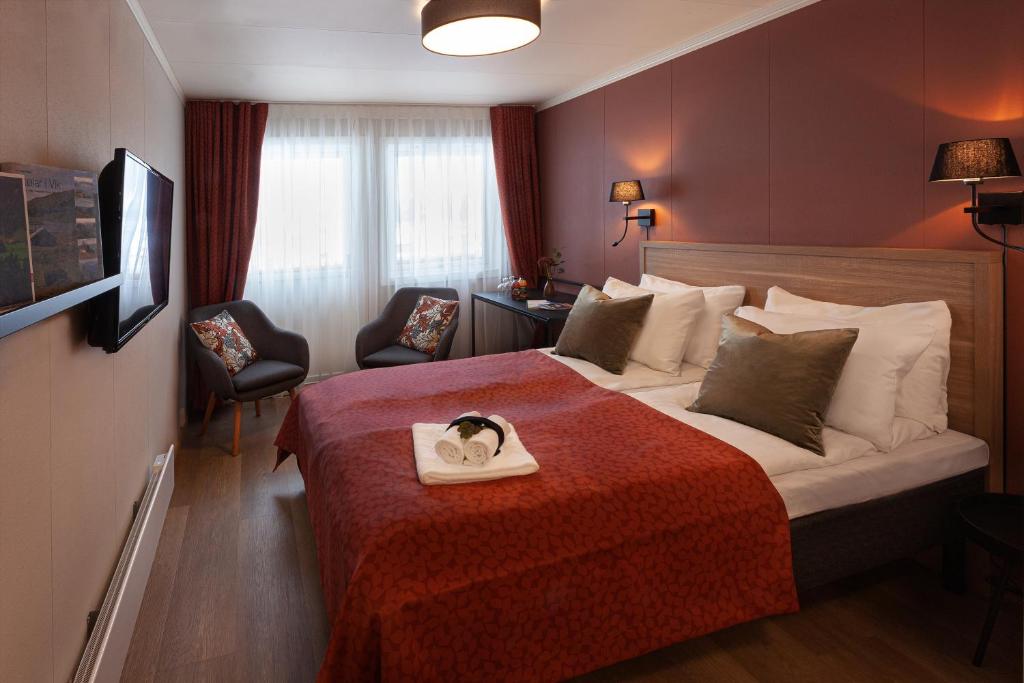 Vikøyri的住宿－布利克斯酒店，一间酒店客房,配有一张带毛巾的床