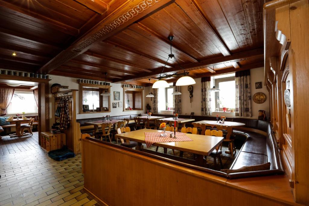 a dining room with wooden ceilings and tables and chairs at Gasthof / Pension Götzfried in Tegernheim