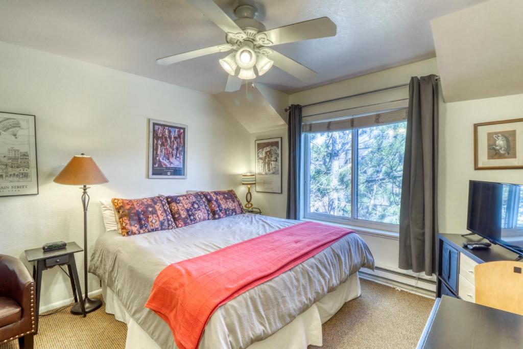 a bedroom with a bed with a ceiling fan and a window at Park City Getaway in Park City