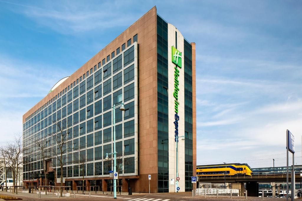 a building with a yellow bus on the side of it at Holiday Inn Express Amsterdam - Sloterdijk Station, an IHG Hotel in Amsterdam