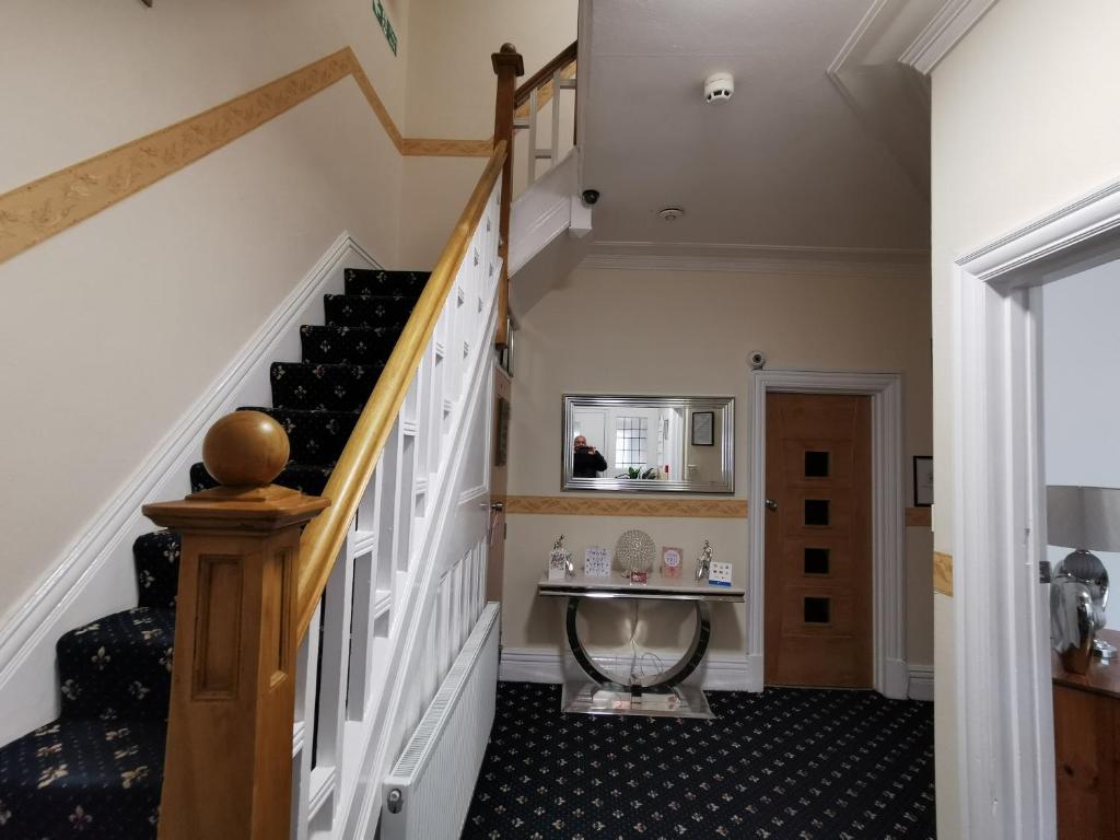 a hallway with a staircase and a sink in a house at Sunnydale in Blackpool