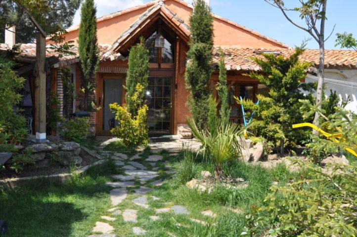 a house with a garden in front of it at Hospedium Hacienda Las Cavas in Olmedo