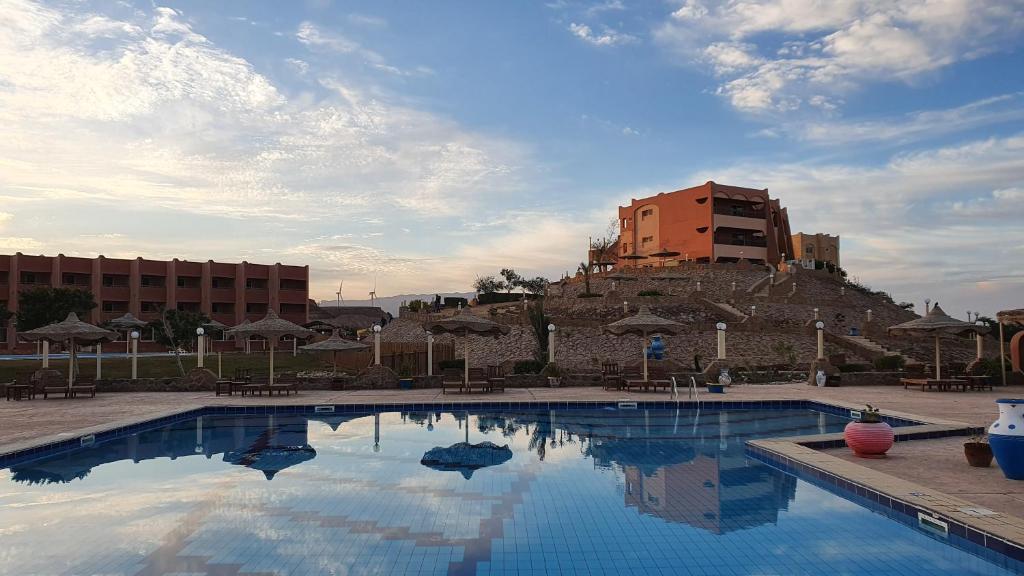 a large swimming pool with a building in the background at Fanar Hotel in Ain Sokhna