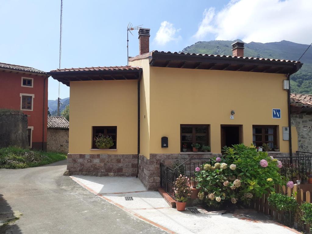 a yellow house with a fence and a street at Casa Llorente in Meré