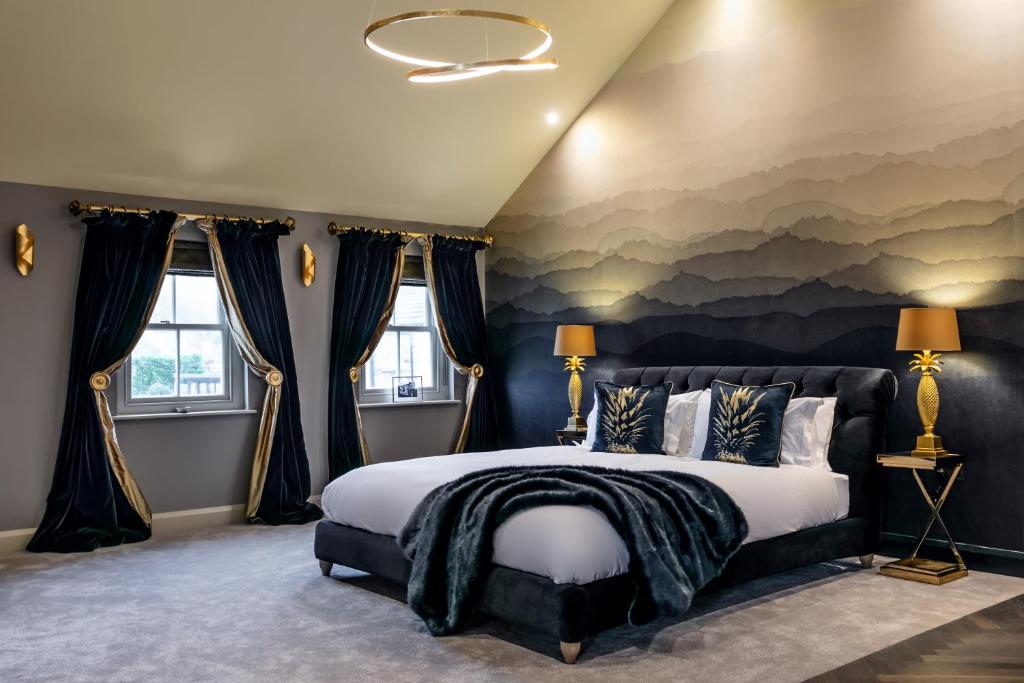 a bedroom with a large bed with a painting on the wall at The Old Hay Shed in Cartmel