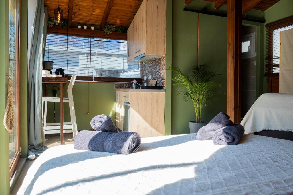 1 dormitorio con 1 cama con toallas en Wood Aesthetic Steps from the Sea, en Tesalónica