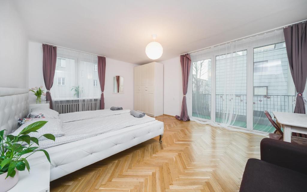 a large white room with a large bed in it at Sunshine Parkside Hideaway - 3 Bedroom in Kraków