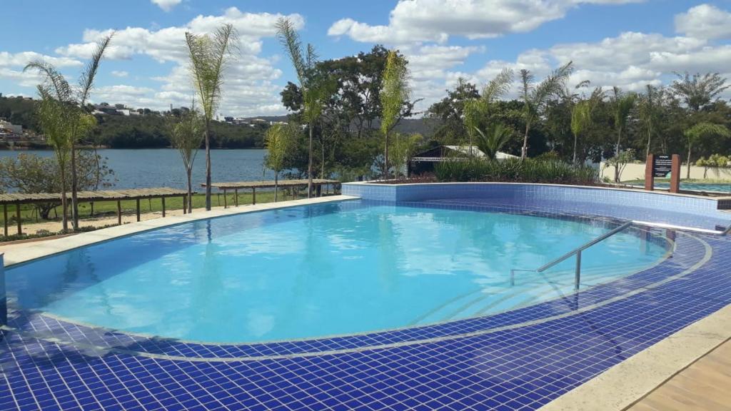 a large swimming pool next to a body of water at ILHAS DO LAGO ECO RESORT in Caldas Novas