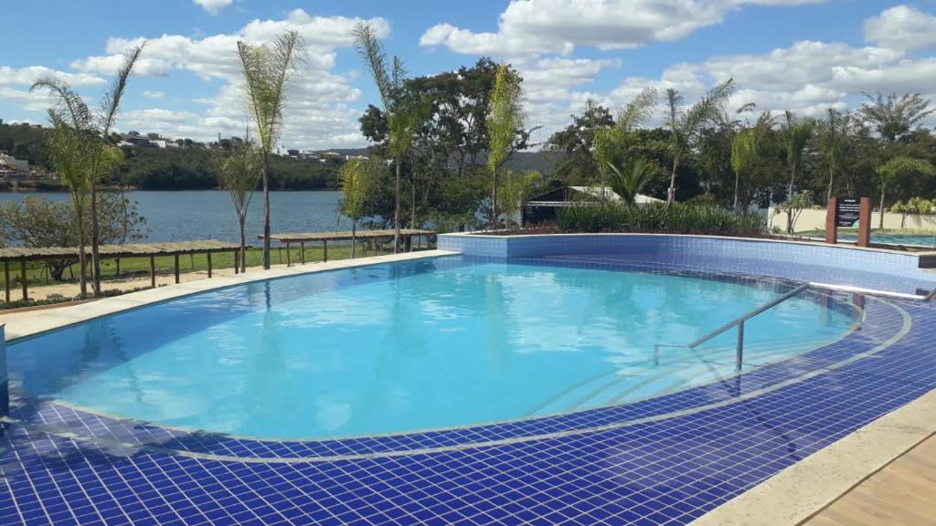 ein großer Pool neben einem Wasserkörper in der Unterkunft ILHAS DO LAGO ECO RESORT in Caldas Novas