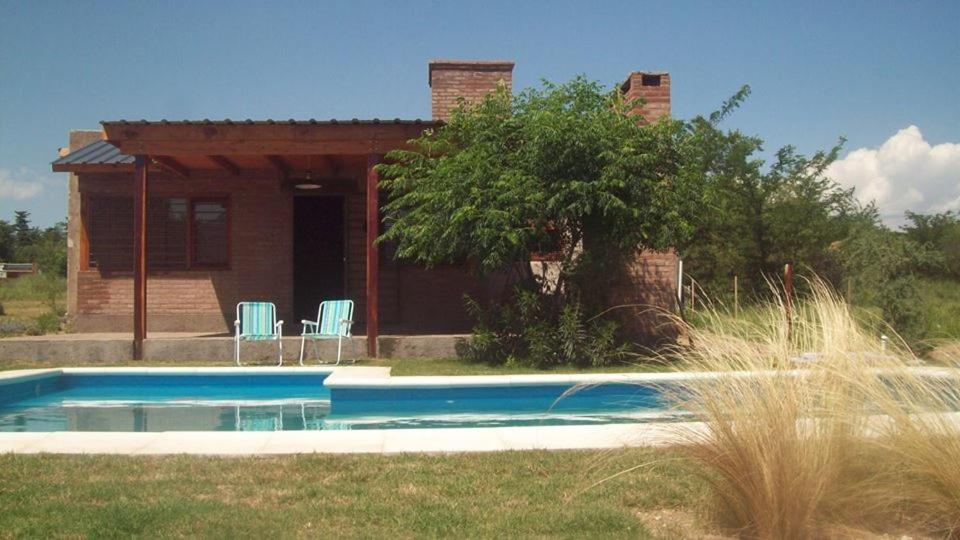 une maison avec une piscine en face de celle-ci dans l'établissement Cabaña El Mirador de Bialet Masse, à Villa Parque Siquiman