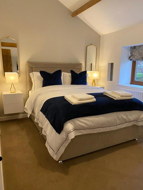 a bedroom with a large bed with blue pillows at The Bothey in Brampton