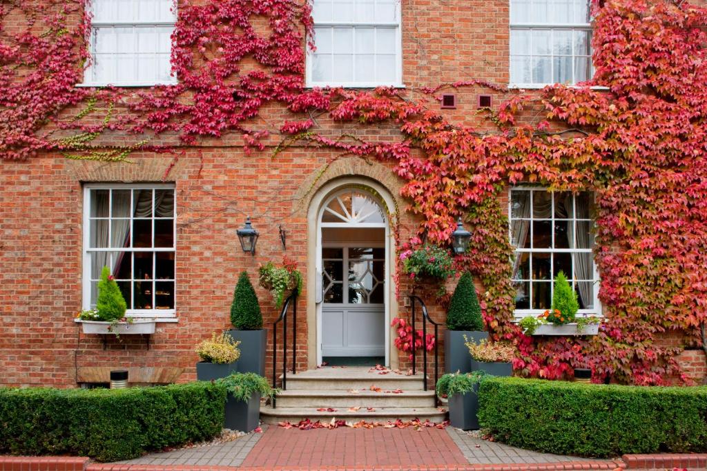 una casa de ladrillo rojo con flores. en Holiday Inn Milton Keynes East M1 Junc 14, an IHG Hotel, en Milton Keynes