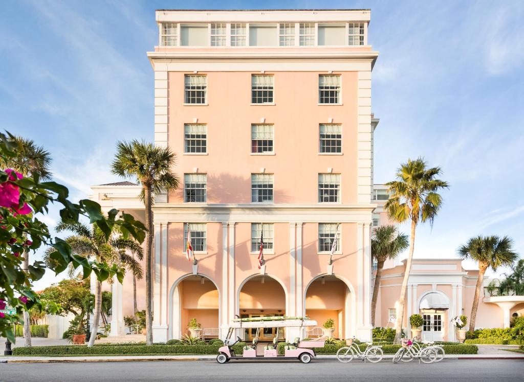 an old car parked in front of a building at The Colony Hotel in Palm Beach