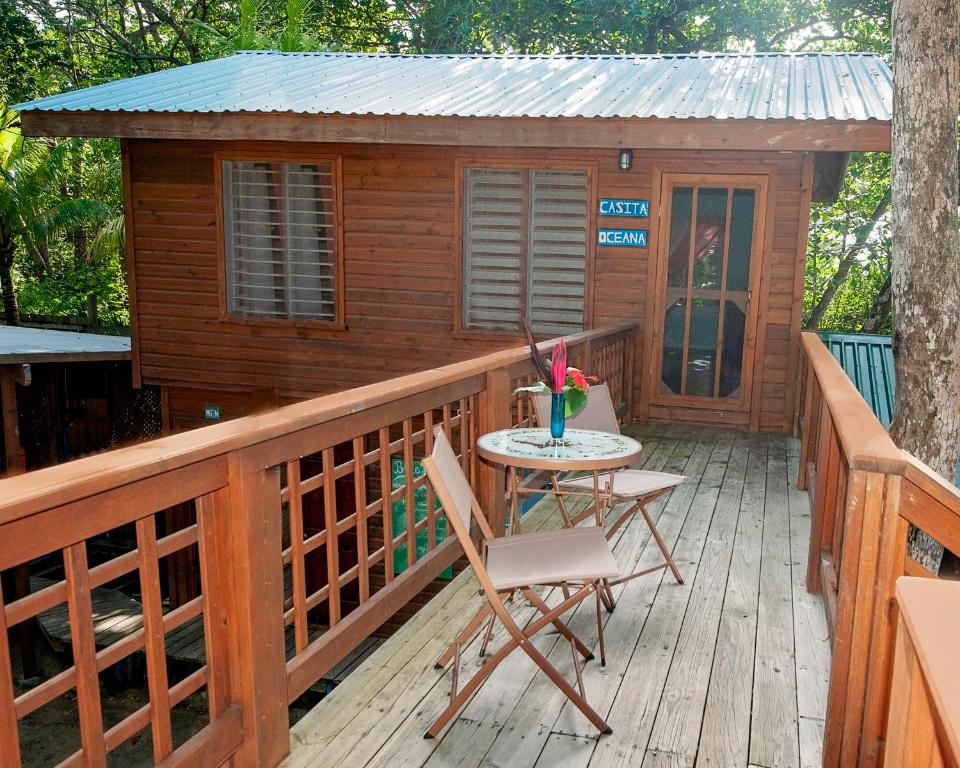 cabina con mesa y sillas en la cubierta en Casita Océana, en Sandy Bay