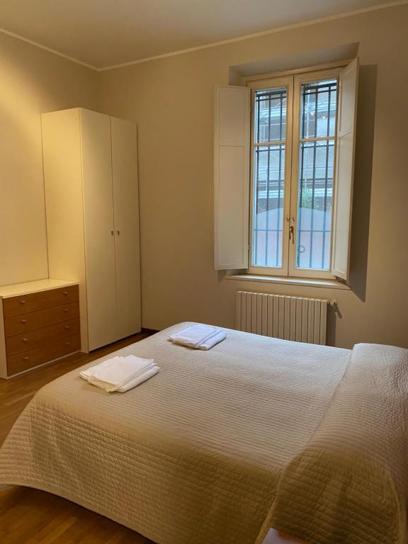 a bedroom with a large white bed and a window at Marconi 18 in Gallarate