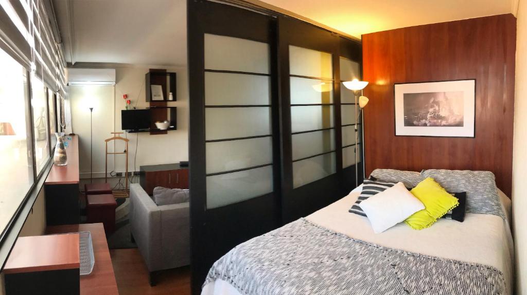 a bedroom with a bed and a sliding glass door at Estudio en el Golf in Santiago