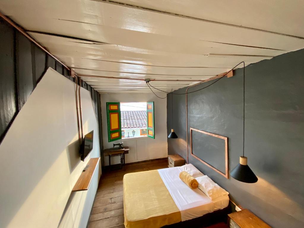 サレントにあるThe Corner House Hostelのベッドと窓が備わる小さな客室です。
