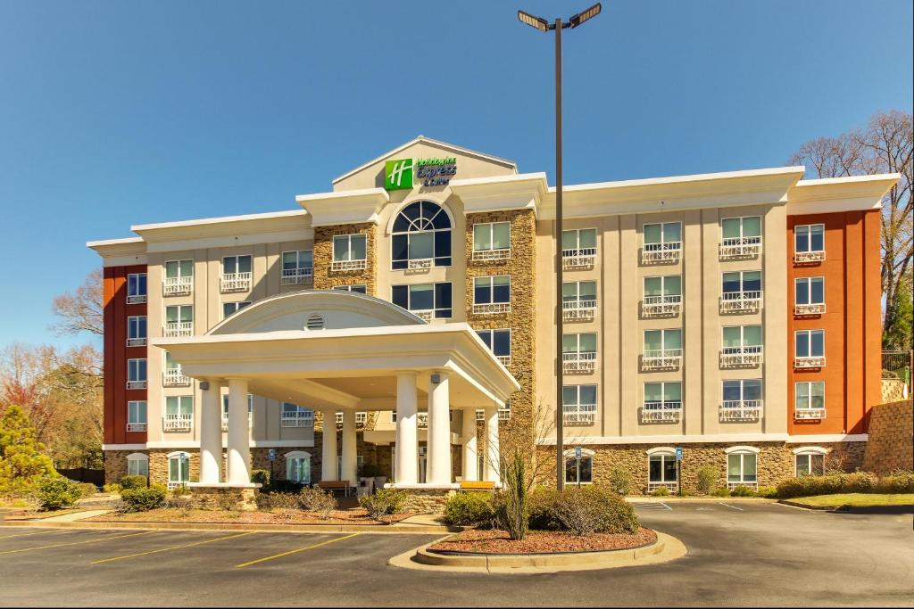 a hotel with a large building with a flag at Holiday Inn Express Hotel & Suites Columbus-Fort Benning, an IHG Hotel in Columbus