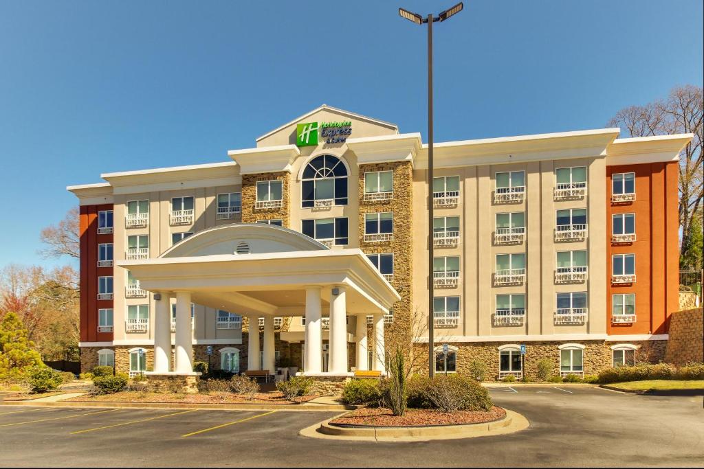 a hotel with a large building with a flag at Holiday Inn Express & Suites Columbus - Ft Benning Maingate by IHG in Columbus