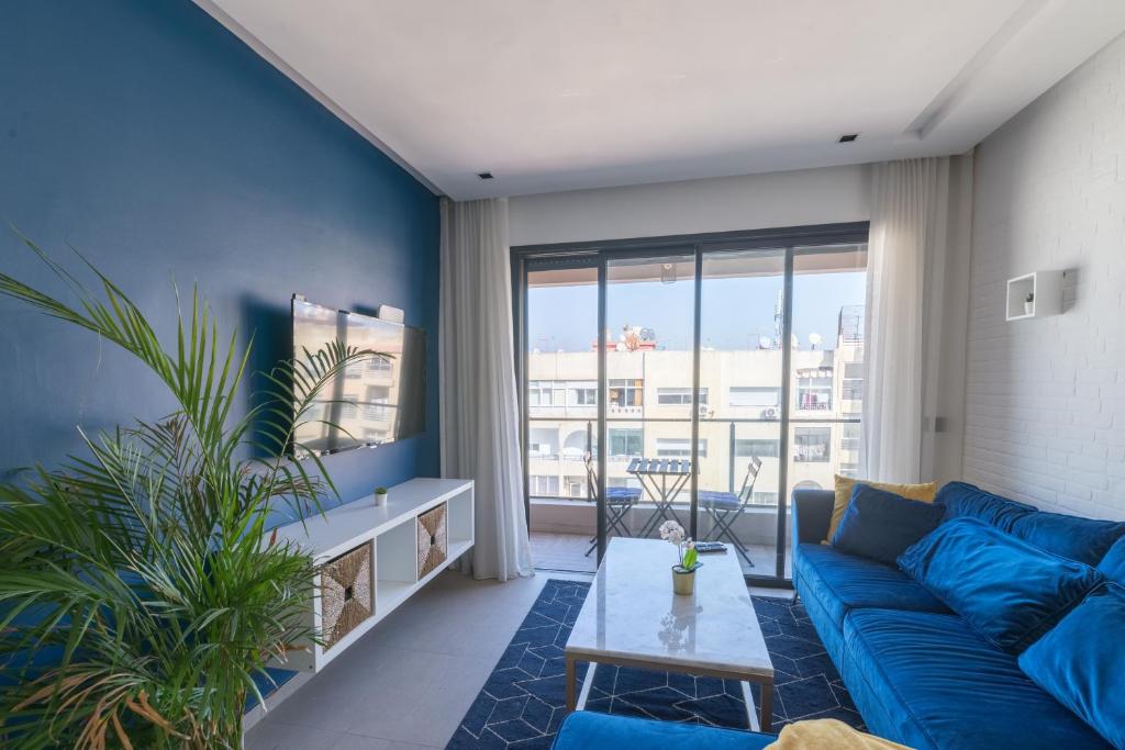 a living room with a blue couch and a table at SPECTACULAR 2 BEDROOMS IN THE HEART OF CASABLANCA in Casablanca