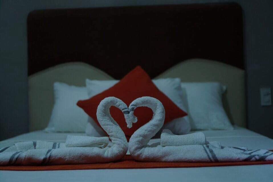 7 Meadows Inn في تاغبيلاران سيتي: سرير بجعتين مصنوعة من المناشف
