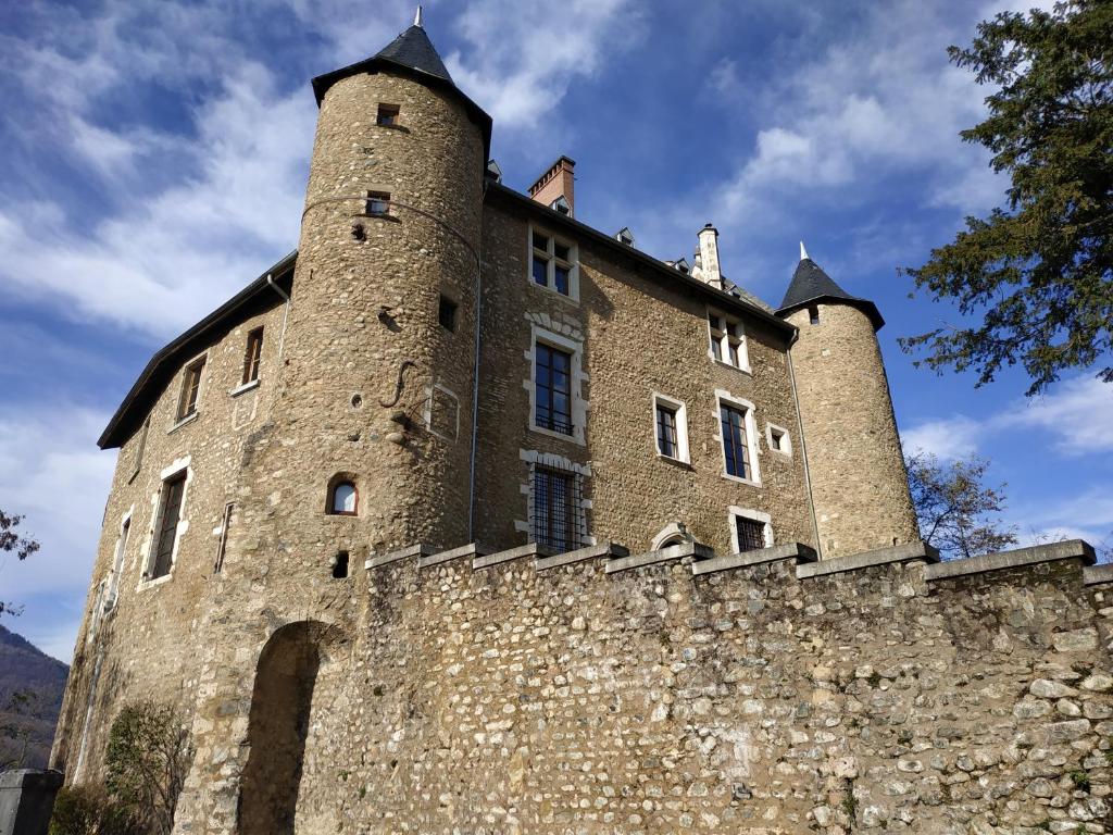 a castle with two towers on a stone wall at Appartement château Uriage-Chamrousse in Saint-Martin-dʼUriage
