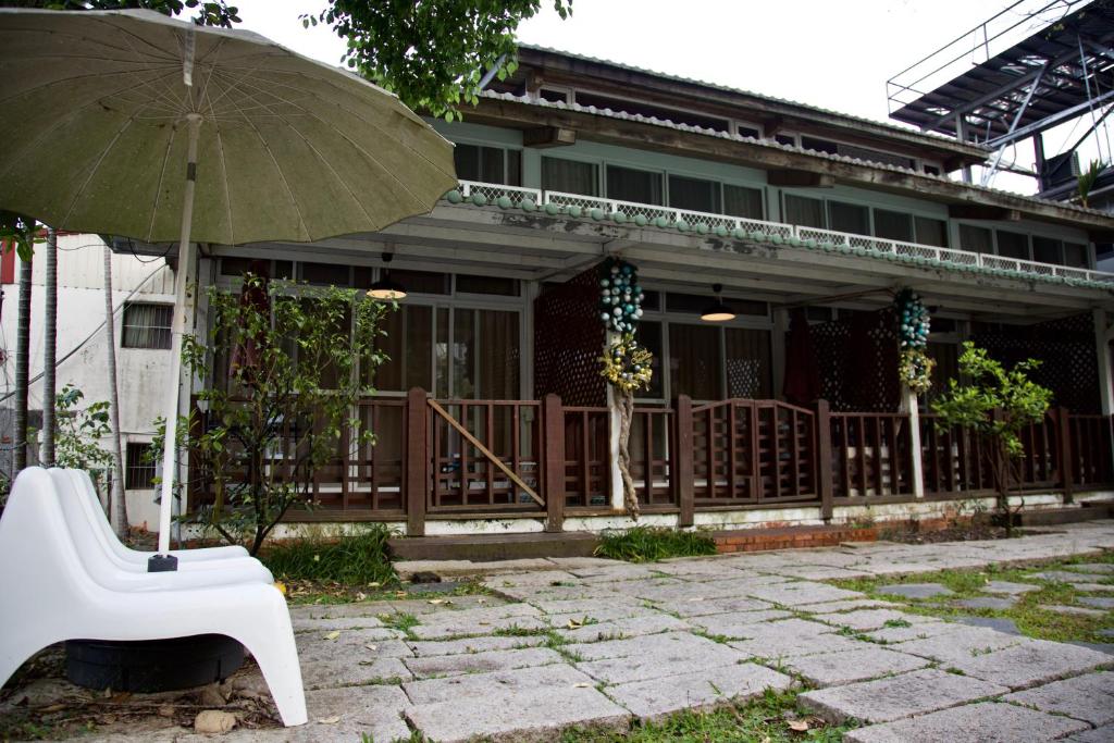 a house with a white chair and an umbrella at Sun Moon Lake Full House Resort in Yuchi