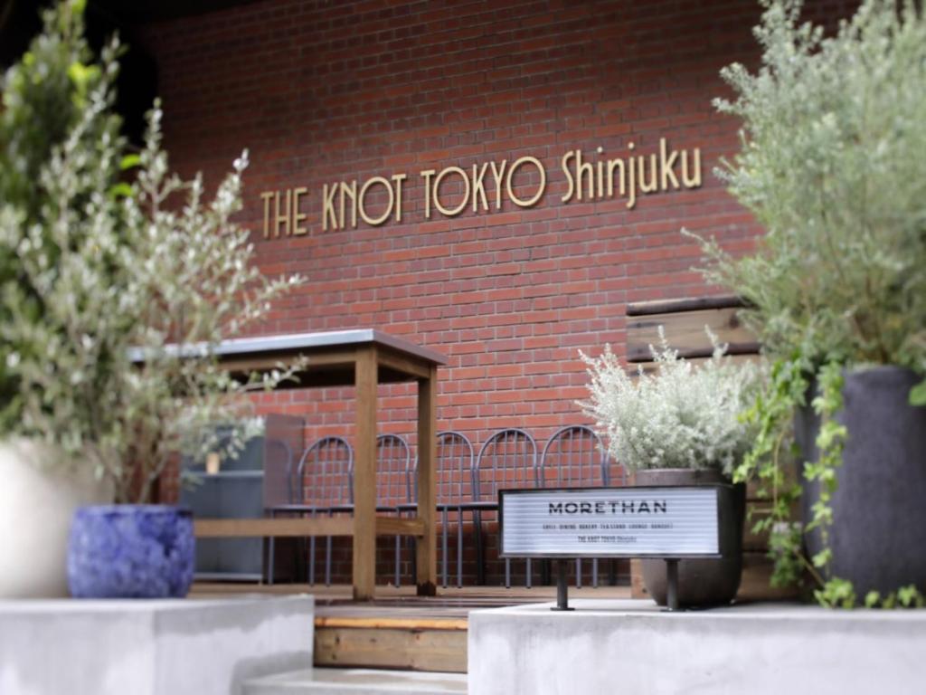 a sign in front of a brick building at THE KNOT TOKYO Shinjuku in Tokyo