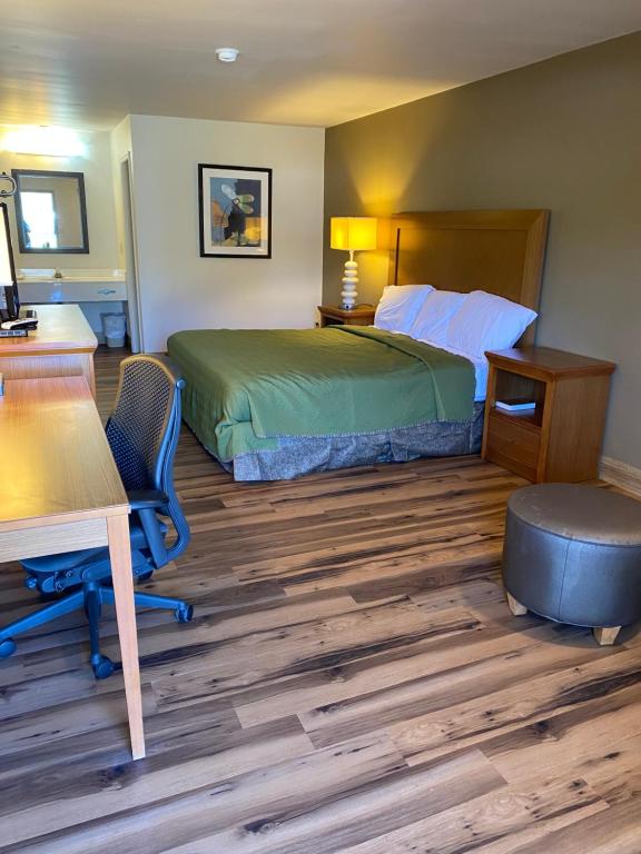 een hotelkamer met een bed, een bureau en een tafel bij Countryside Inn in Harleyville
