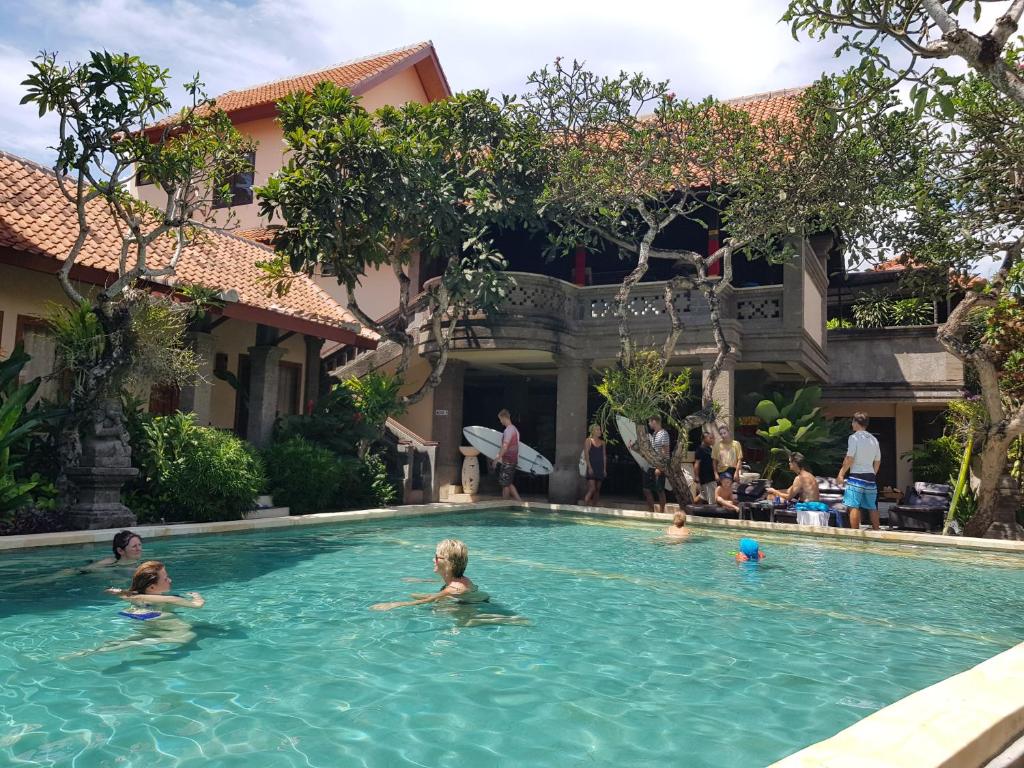 een groep mensen die zwemmen in een zwembad bij Puri Mesari Hotel in Sanur