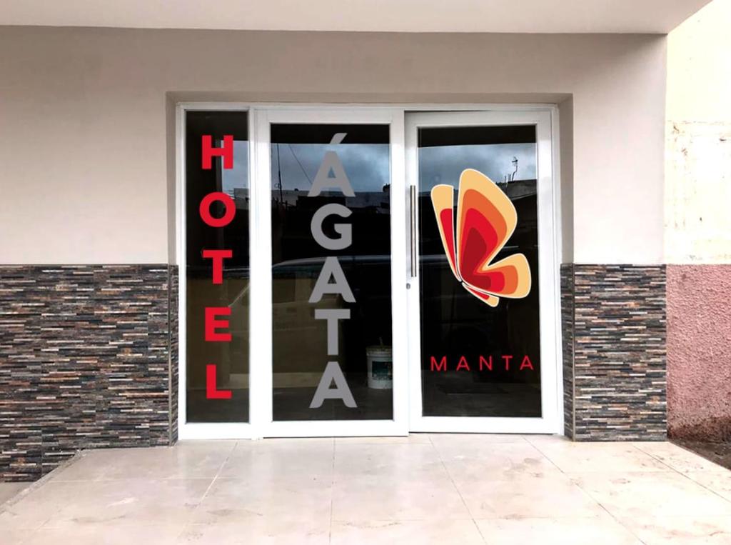 una tienda con una gran puerta de cristal con un zapato. en Hotel Ágata Manta, en Manta