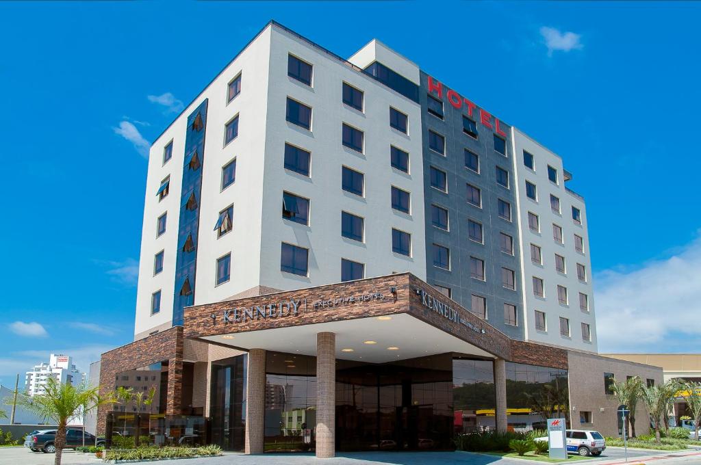 a hotel building with a sign on top of it at Kennedy Executive Hotel in São José