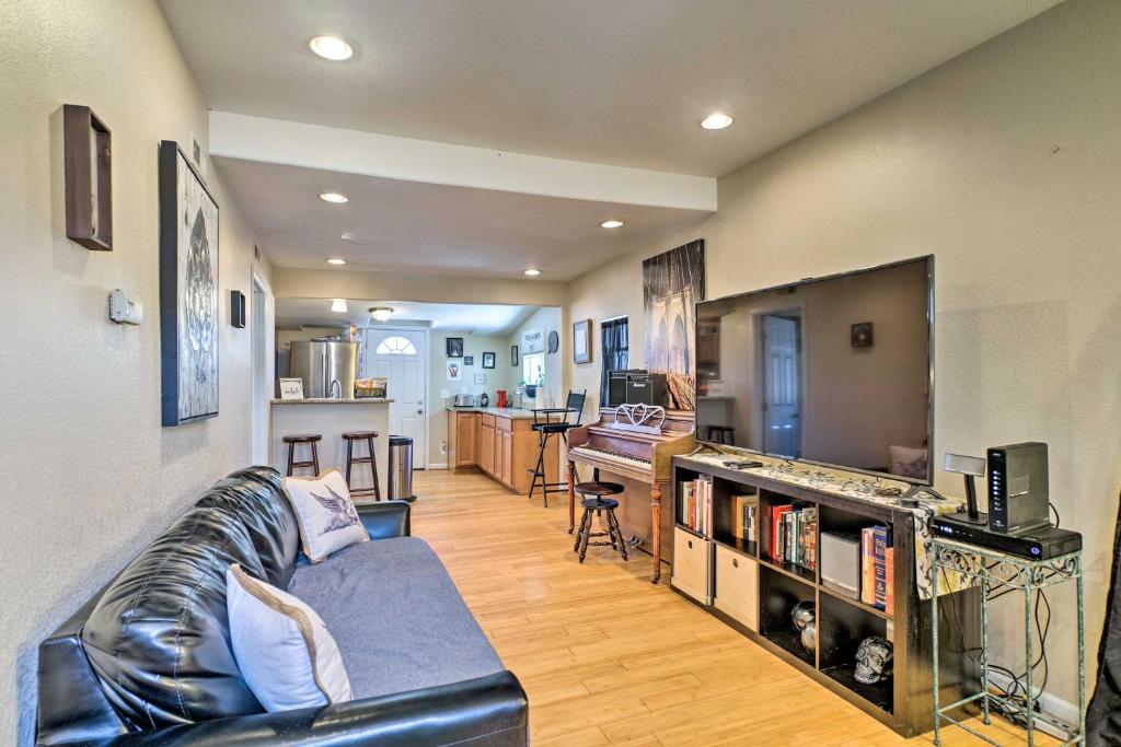 a living room with a leather couch and a kitchen at Downtown Home with Grill 5 Mi to Garden of the Gods in Colorado Springs