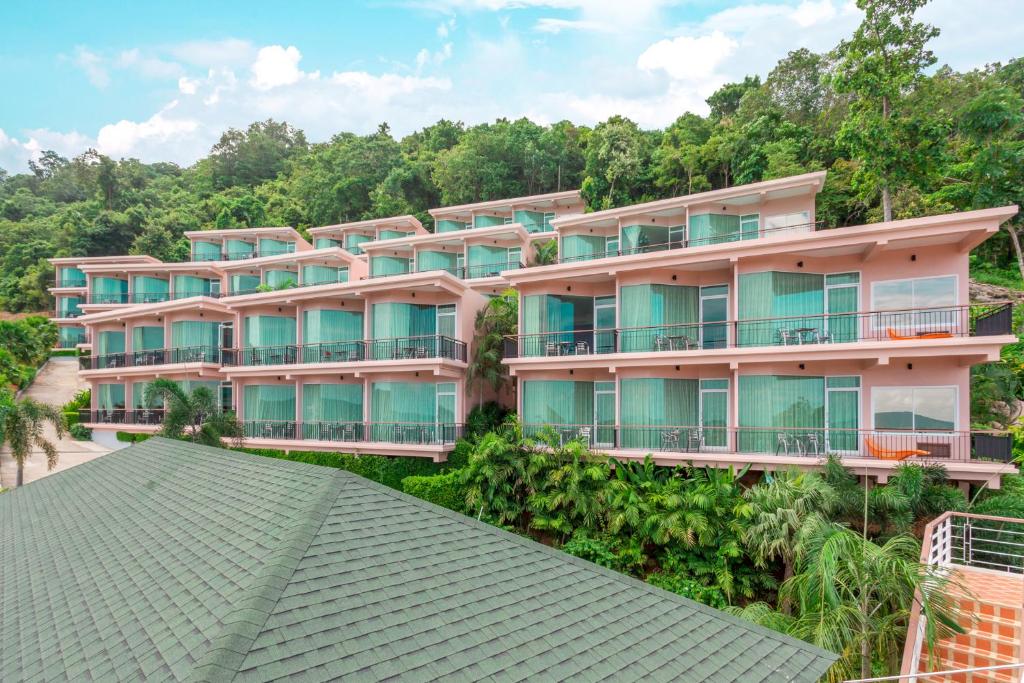 an apartment building on a hill with trees at The View Rawada Phuket in Rawai Beach