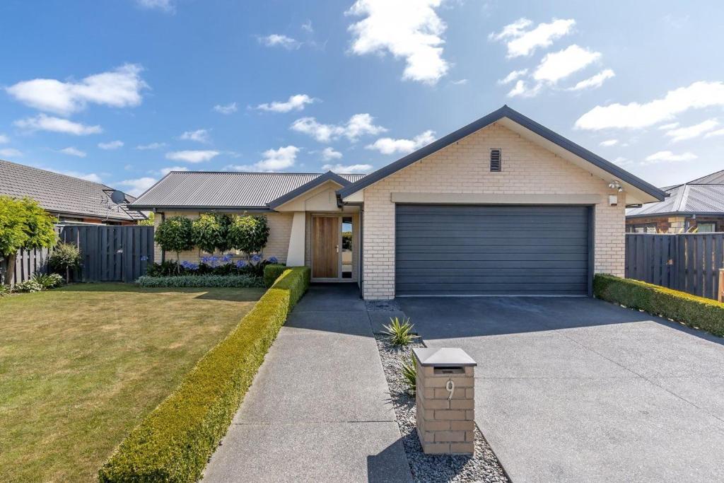 a house with a garage on a driveway at Airport, motorway, shopping handy in Christchurch