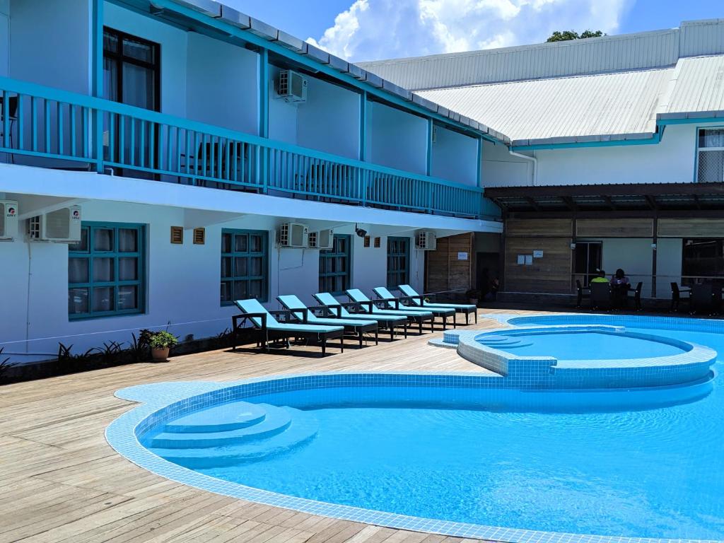 a swimming pool in front of a building at Pacific Crown Hotel in Honiara