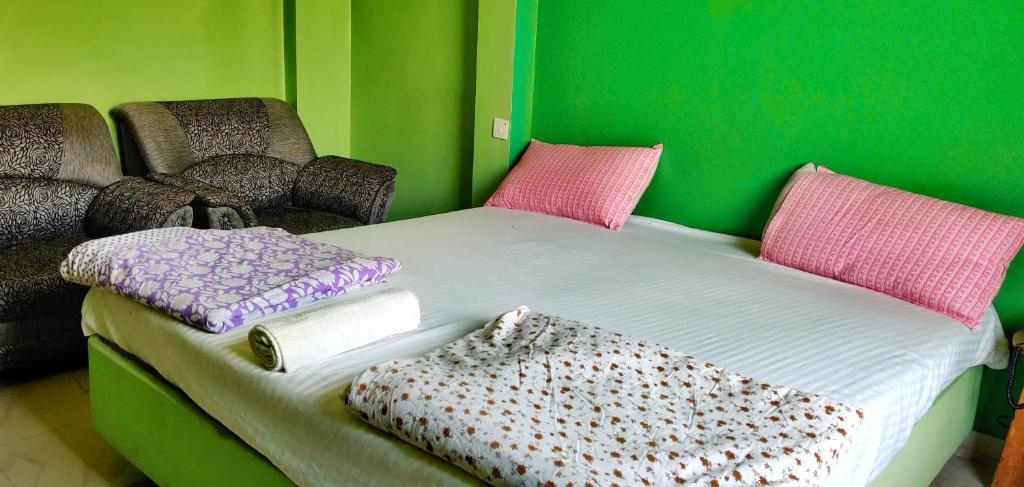 małe łóżko w pokoju z zieloną ścianą w obiekcie Hotel Narayan Palace w mieście Amarsar