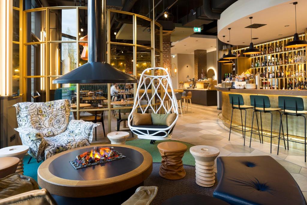 a lobby with chairs and a fire pit and a bar at Hotel Indigo Dresden - Wettiner Platz, an IHG Hotel in Dresden