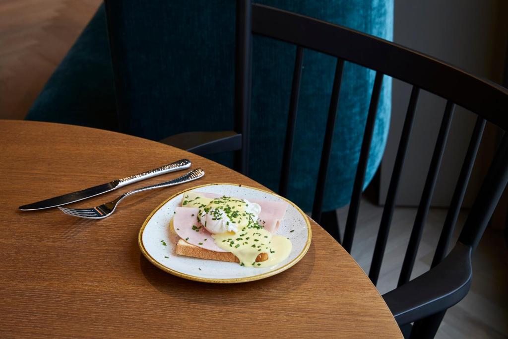 a plate of food sitting on a wooden table at Hotel Indigo Dresden - Wettiner Platz by IHG in Dresden